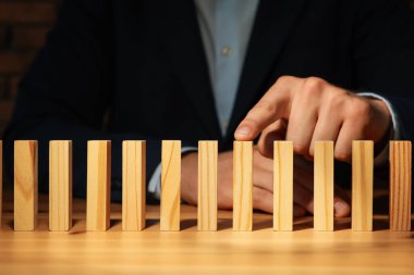 Risk. Masasında tahta bloklar olan adam, yakın plan.