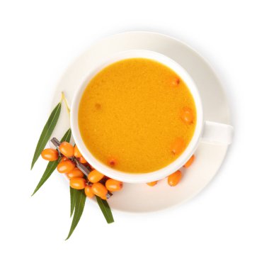 Cup of sea buckthorn tea and fresh berries isolated on white, top view