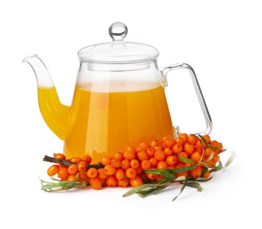Sea buckthorn tea in glass teapot and fresh berries isolated on white