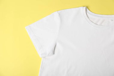 White t-shirt on yellow background, top view. Mockup for design