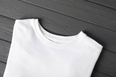 White t-shirt on grey wooden table, top view. Mockup for design