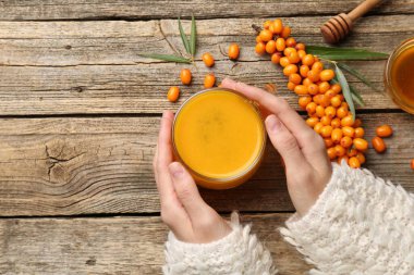 Ahşap masada deniz dikenli çay içen bir kadın. Metin için boşluk