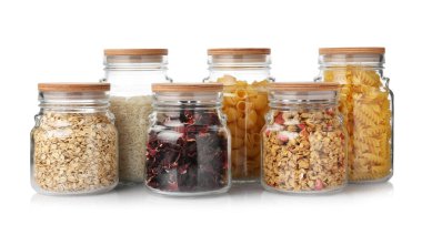 Glass jars with different products isolated on white