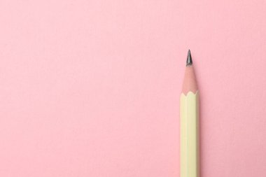 Pembe arka planda keskin bir grafit kalem, üst manzara. Metin için boşluk