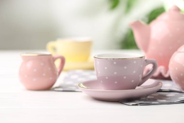 Beyaz ahşap masadaki çocuklar için seramik çay seti bulanık arka plan, yakın plan