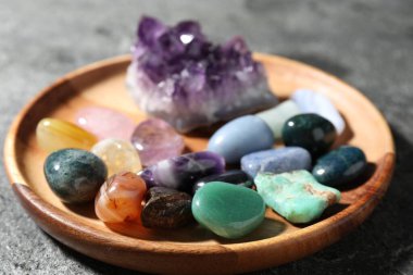 Gri masadaki farklı güzel taşlar, yakın plan.