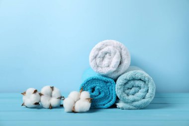 Temiz havlular ve açık mavi arka planda pamuk çiçekleri. Metin için boşluk