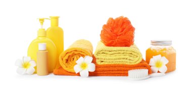 Taze havlu yığını, kozmetik ürünler, sünger, fırça ve tesisat çiçekleri beyaza izole edilmiş.