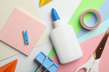 Beyaz zemin üzerinde yapıştırıcı ve diğer kırtasiye düz yatıyordu