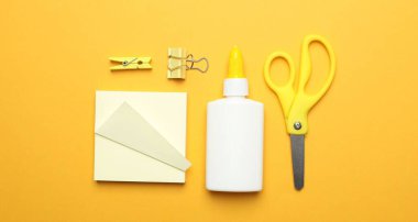 Sarı zemin üzerine yapıştırıcı ve diğer kırtasiye malzemesi, düz yatıyordu