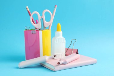 Açık mavi arkaplanda yapıştırıcı ve diğer kırtasiye malzemesi