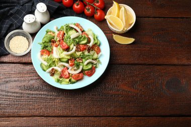 Ahşap masada servis edilen kalamar, sebze ve cevizli nefis salata. Metin için boşluk