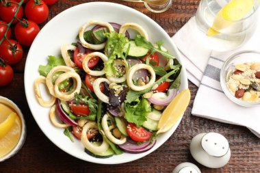 Ahşap masada servis edilen ahtapot halkaları ve sebzeli leziz salata.