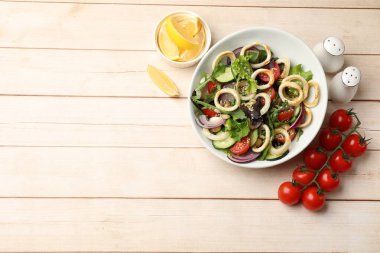 Ahşap masada servis edilen ahtapot halkaları ve sebzeli nefis salata. Metin için boşluk