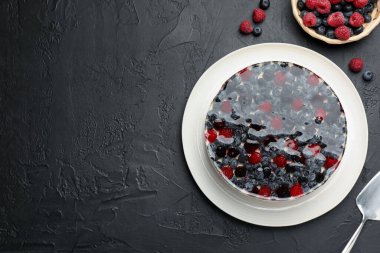 Siyah desenli masada servis edilen böğürtlenli leziz cheesecake. Metin için boşluk