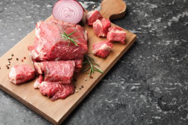 Çiğ et ve baharat parçaları siyah mermer masada, yakın plan. Metin için boşluk