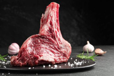 Bir parça çiğ et ve baharat siyah masada, yakın plan. Metin için boşluk