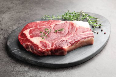 Gri masadaki çiğ et ve baharatlar, yakın plan.