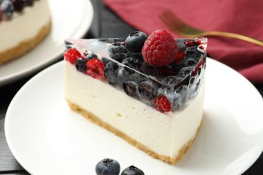 Bir parça lezzetli peynirli kek, masada böğürtlenli, yakın plan.