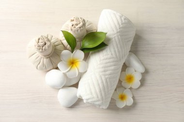 Beautiful spa composition with herbal bags on white wooden table, flat lay