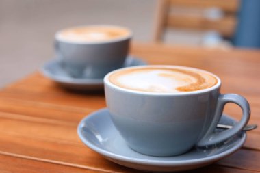 Ahşap masanın üzerinde bir fincan aromatik kahve, yakın plan.