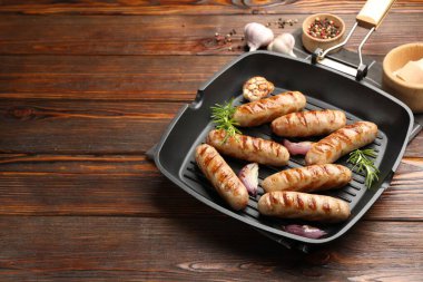 Ahşap masada ızgara sosis ve baharatlı tava. Metin için boşluk