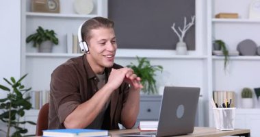 Kulaklıklı bir adam bilgisayarla kapalı masa testinden geçiyor.