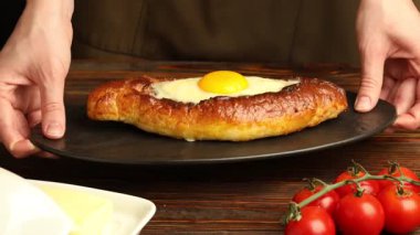 Ahşap masada nefis khachapuri 'si olan kadın, yakın plan.