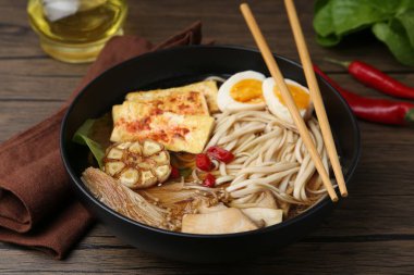 Ahşap masadaki mantarlı, Enoki ve Kral istiridyeli lezzetli ramen.