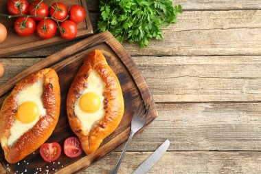 Tahta masada servis edilen peynir ve yumurtalı leziz khachapuriler. Metin için boşluk