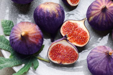 Taze incir ve yeşil yaprak masanın üstünde.