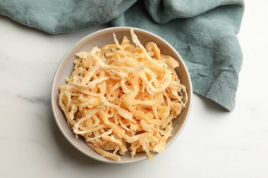 Beyaz mermer masada, tabakta kurutulmuş mürekkep balığı talaşı.