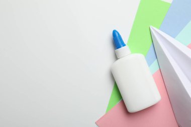 Beyaz arka planda yapıştırıcı ve renkli kağıt düz. Metin için boşluk