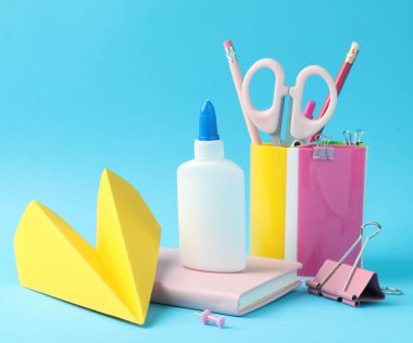 Açık mavi arkaplanda yapıştırıcı ve diğer kırtasiye malzemesi