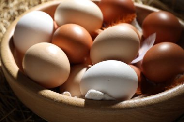 Çiğ tavuk yumurtası ve tüyler masada, yakın plan.