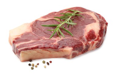 Bir parça çiğ et ve beyaz üzerine izole edilmiş baharatlar.