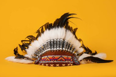 Traditional warbonnet (Native American chief headdress) on yellow background