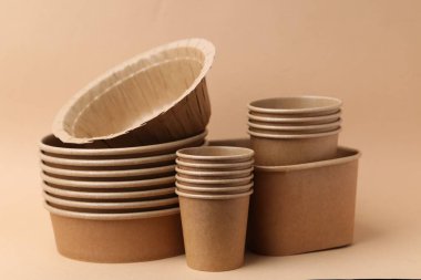Set of disposable tableware on dark beige background, closeup