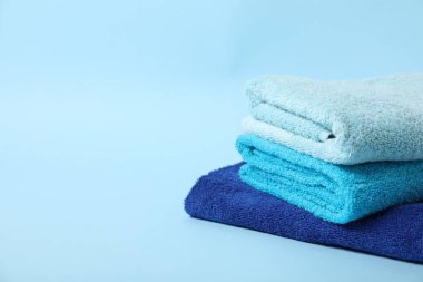 Açık mavi arka planda bir yığın temiz havlu. Metin için boşluk