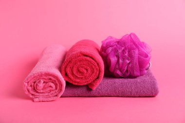 Pembe arka planda taze havlu ve sünger.