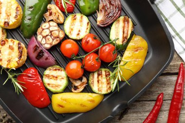 Tavada ızgara sebze ve baharat, ahşap masa, üst manzara.