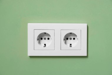 İçerideki yeşil duvarda elektrik prizleri.