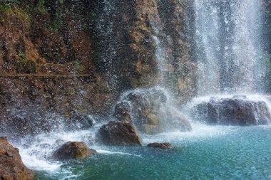 Güzel bir dağ şelalesi ve kayaların manzarası.