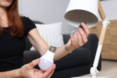 Evde ampulü değiştiren kadın, yakın plan.