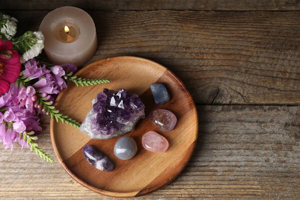Красивые камни, цветы и горящая свеча на деревянном столе, плоская лежала. Пространство для текста