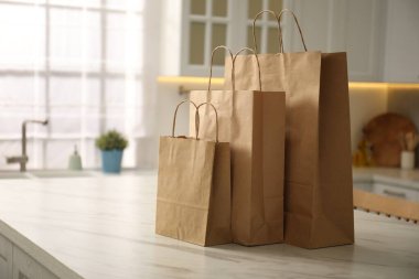 Mutfaktaki beyaz mermer masada kağıt torbalar. Metin için boşluk