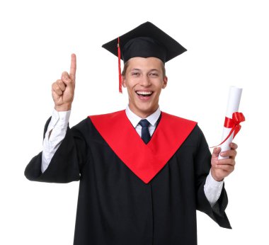 Mezuniyet elbisesi ve havan tahtasıyla beyaz arka planda diplomalı mutlu genç bir adamın portresi.