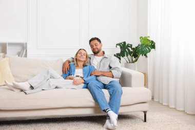 Mutlu çift evdeki kanepede birlikte vakit geçiriyor.