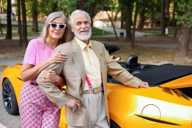 Modern Cabriolet yakınlarında şık bir yaşlı çift.