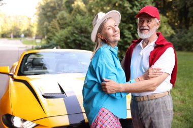 Modern Cabriolet yakınlarında şık bir yaşlı çift.